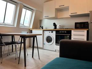 a kitchen with a washing machine and a table at Villa Beauregard in Mers-les-Bains