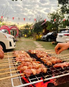 Un groupe de poulets cuisine sur un grill dans l'établissement Wangnamkeaw Goodviewresort, à Ban Kom