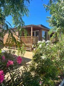 a house with a porch and some flowers at Camping Resort Els Pins in Malgrat de Mar