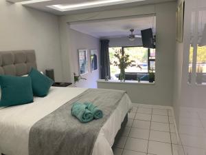 een slaapkamer met een bed met een blauwe handdoek erop bij Footprints Self Catering Solar No Loadshedding in Lanseria
