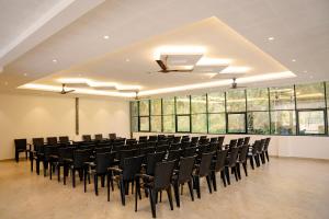 a large room with black chairs and large windows at Bluemist Resorts in Athirappilly