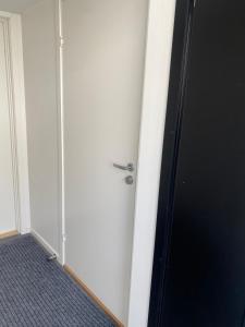 una puerta blanca con mango de plata en una habitación en Small modern appartment en Sogndal