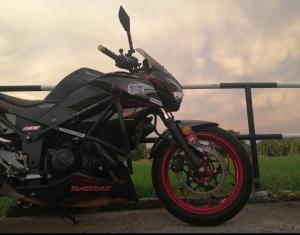 a black motorcycle parked next to a fence at OOI Homestay Alor Setar in Alor Setar