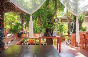 un jardin avec une table, des bancs et des arbres dans l'établissement Wangnamkeaw Goodviewresort, à Ban Kom