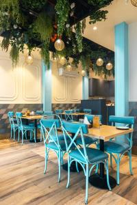 una sala da pranzo con tavoli e sedie blu di Rupam Hotel a Nuova Delhi