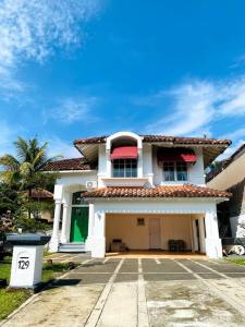 una grande casa bianca con una porta verde di DnS House a Babakan Madang