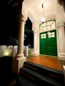 una porta verde in una casa con scala di DnS House a Babakan Madang