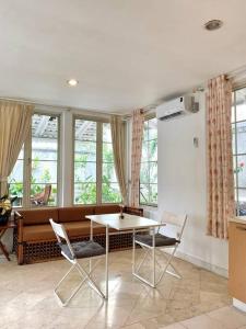 un soggiorno con tavolo, sedie e finestre di DnS House a Babakan Madang