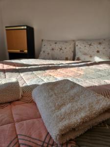 Una cama con una manta y una alfombra. en Apartman Gajic, en Nikšić
