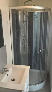 Un baño con ducha y lavabo blanco. en Le studio médocain, en Cussac-Fort-Medoc