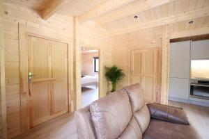 a leather couch in a room with wooden walls at KillarneyCabins ie, Stunning Timber Lodges in Killarney