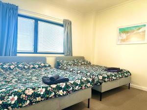 a bedroom with two beds and a window at Bundled Bliss 2 bedroom Condo in Adelaide CBD in Adelaide