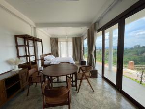 ein Schlafzimmer mit einem Tisch, Stühlen und einem Bett in der Unterkunft Amidst wind in Wang Nam Khieo