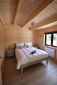 Tempat tidur dalam kamar di KillarneyCabins ie, Stunning Timber Lodges