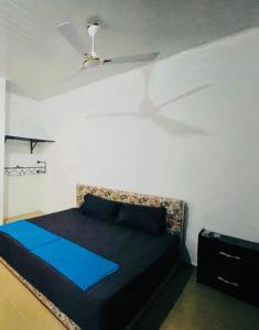 um quarto com uma cama e uma ventoinha de tecto em OLIVER COTTAGE GUESTHOUSE em Yamoransa