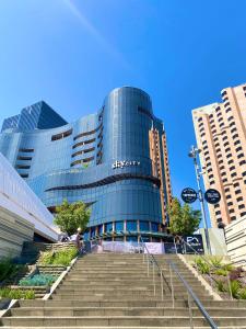 a large glass building with stairs in front of it at Bundled Bliss 2 bedroom Condo in Adelaide CBD in Adelaide