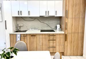 a kitchen with white cabinets and a sink at Townhouses by Readyset at Beach in Melbourne