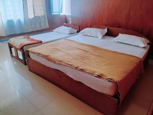 2 camas individuales en un dormitorio con en Vega Residency And Bike Rentals en Madikeri