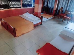 1 dormitorio con 2 camas, mesa y silla en Vega Residency And Bike Rentals en Madikeri