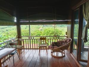 a screened in porch with a chair and a table at Banlung Hill Top House &Trekking in Phumĭ Pôy
