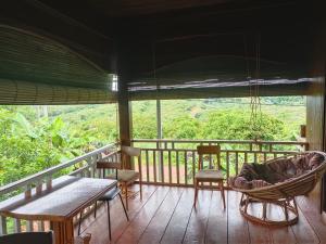 una veranda con amaca e sedie su una terrazza di Banlung Hill Top House &Trekking a Phumĭ Pôy