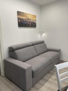 a couch in a living room with a picture on the wall at Bnb apartment Ferrara in Udine