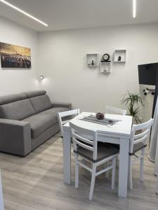 a living room with a table and chairs and a couch at Bnb apartment Ferrara in Udine