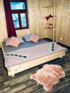 - un lit en bois avec des oreillers dans l'établissement Chata na sjezdovce, à Josefův Důl