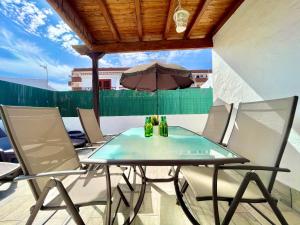 a table and chairs on a balcony with an umbrella at Sunlight Place Bungalow in San Bartolomé de Tirajana