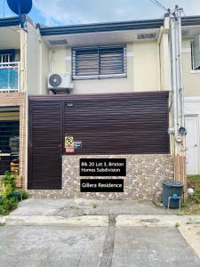 un edificio con una puerta de garaje con un cartel. en Gillera Staycation in Lipa en Lipa