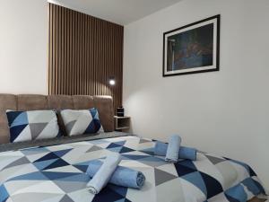 a bedroom with a bed with blue and white pillows at Nikolic Apartment 2 in Leskovac