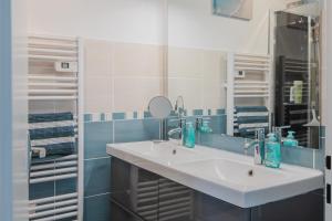 a bathroom with a white sink and a mirror at Gîte de la Marina dans la presqu'île de Lézardrieux in Lézardrieux