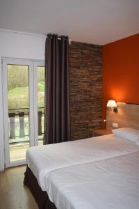 ein Schlafzimmer mit einem großen Bett und einem Fenster in der Unterkunft HOTEL VICTORIA in Arinsal