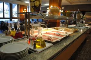 a buffet line with plates of food on a table at HOTEL VICTORIA in Arinsal