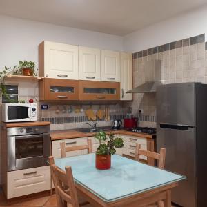 eine Küche mit einem Tisch und einem Kühlschrank aus Edelstahl in der Unterkunft Appartamento centro storico Firenze, Luna House in Florenz