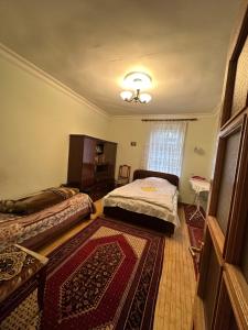 a bedroom with two beds and a rug at Ijevan beautiful Home in Ijevan