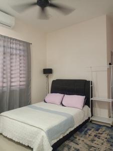 ADSA homestay في Kampong Wakaf Tengah: غرفة نوم مع سرير مع وسادتين ورديتين