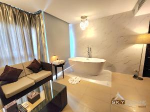 Sky dome resotel في بانكوك: غرفة معيشة مع أريكة وحوض استحمام
