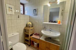 y baño con lavabo, aseo y espejo. en Chambres Les Tilleuls, en Poullaouen