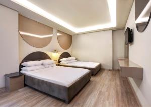 2 camas en una habitación de hotel con TV en Park Çağlayan Hotel, en Estambul