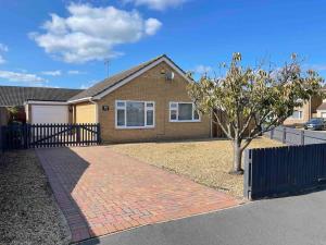 a house with a brick sidewalk in front of a tree at lodge in the heart of Bourne in Lincolnshire