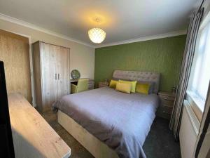 1 dormitorio con 1 cama grande con almohadas amarillas en lodge in the heart of Bourne en Lincolnshire