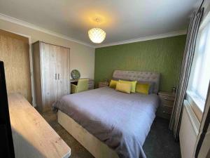 a bedroom with a large bed with yellow pillows at lodge in the heart of Bourne in Lincolnshire