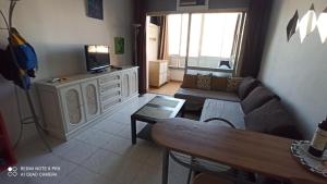 ein Wohnzimmer mit einem Sofa und einem TV in der Unterkunft MarMontaña in Fuengirola