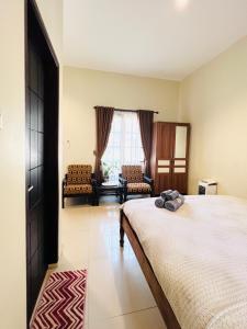 - une chambre avec un lit, un canapé et une fenêtre dans l'établissement Juni Residence, à Pineleng