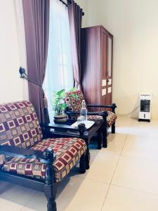 - un salon avec deux chaises et une table dans l'établissement Juni Residence, à Pineleng