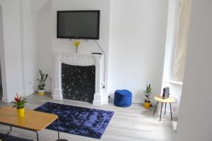 a living room with a fireplace with a tv above it at Gresham Home - close to ExCel, contractors, relocators, paid parking in London