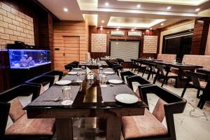 a dining room with tables and chairs and a television at Gogol Beach Resort in Mandarmoni