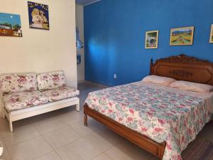 a bedroom with a bed and a couch at Casa na Praia com Piscina in Costa Dourada