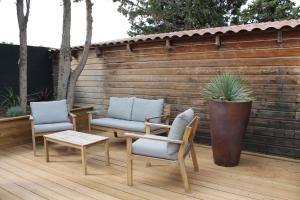 un patio con 2 sillas, una mesa y un banco en Domaine de la Palme, en Lapalme